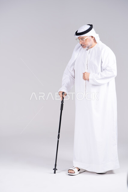 Elderly Emirati Man Walking with Cane in Studio