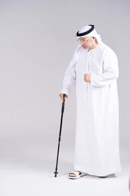 رجل إماراتي مسن يمشي بالعصا في الاستوديو