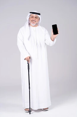 رجل إماراتي مسن يحمل هاتف ذكي مع عصا مشي