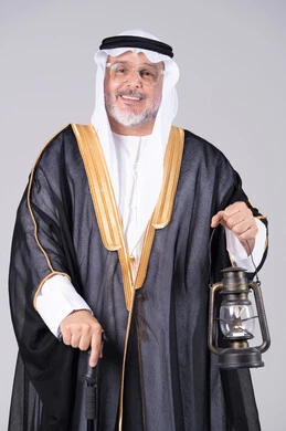 رجل سعودي مسن بالبشت التقليدي يحمل فانوسا قديما