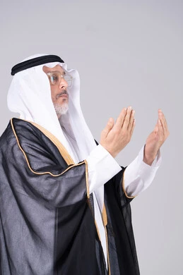 Emirati Man in Traditional Bisht Praying Profile View