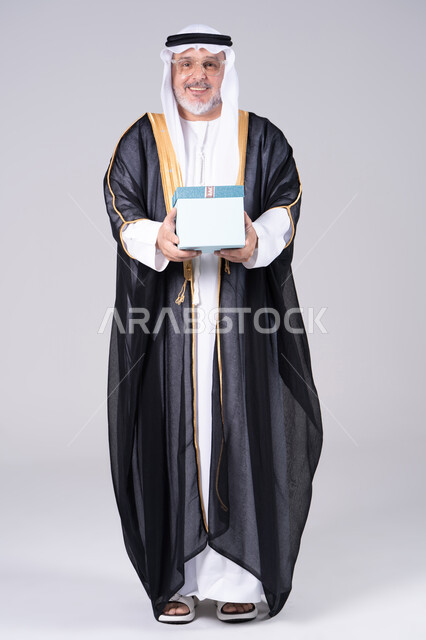 Emirati Man in Traditional Bisht Holding Gift Box
