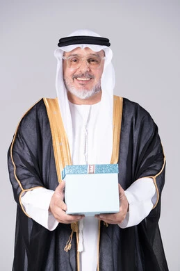 رجل إماراتي يحمل صندوق هدايا في الاستوديو