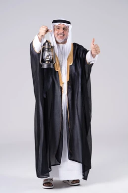 رجل إماراتي بالبشت يحمل فانوساً وعلامة الإعجاب