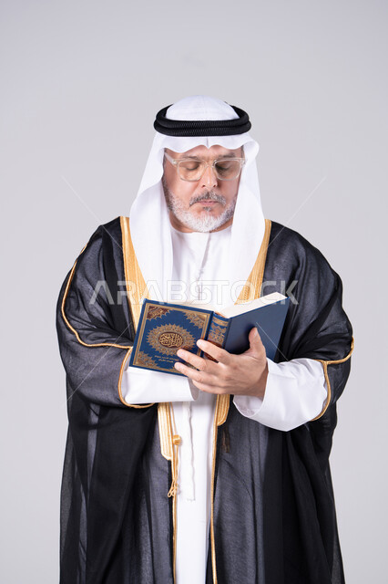 رجل إماراتي بالبشت التقليدي يقرأ القرآن الكريم