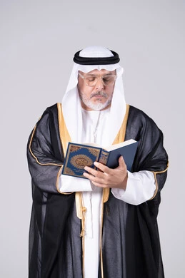 Emirati Man in Traditional Bisht Reading Quran