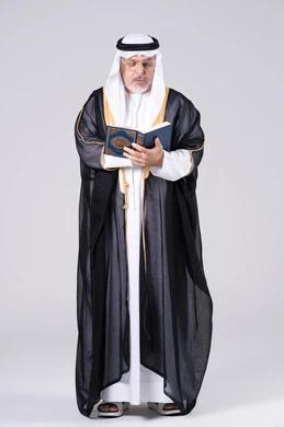 Senior Emirati Man Reading Holy Quran in Traditional Bisht