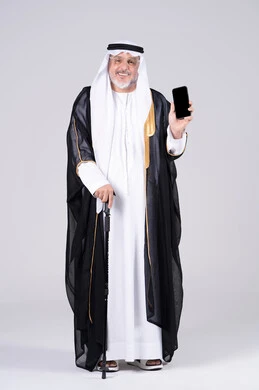 رجل إماراتي بزي البشت يمسك هاتف ذكي