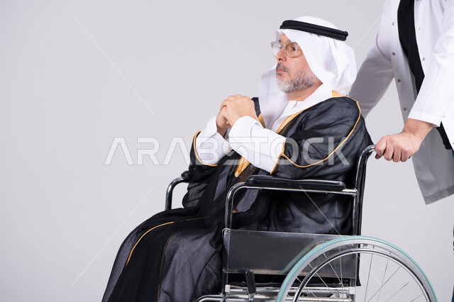 رجل إماراتي مسن على كرسي متحرك مع مقدم الرعاية الصحية