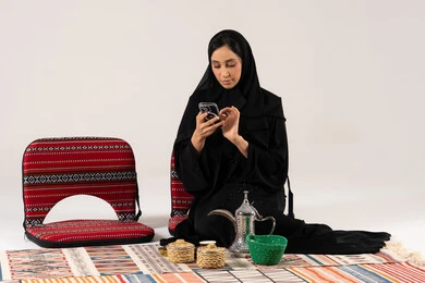 Saudi Woman in Abaya Using Smartphone with Dalla