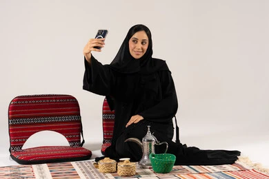 امرأة سعودية بالعباءة تلتقط سيلفي مع دلة القهوة امرأة سعودية بالعباءة تلتقط سيلفي مع دلة القهوة