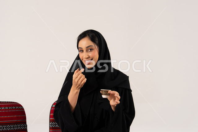 Saudi Woman Eating Dates and Drinking Arabic Coffee