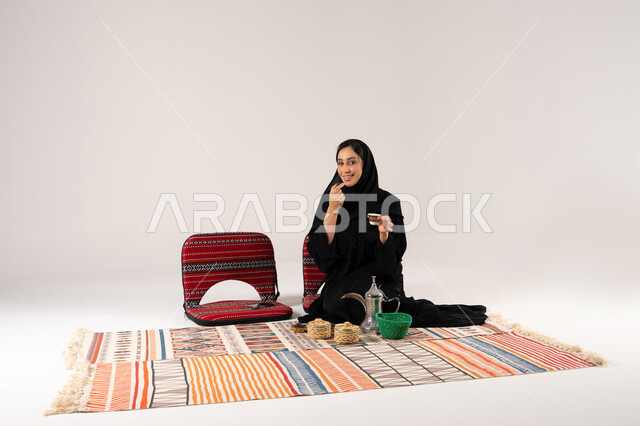 امرأة سعودية مع القهوة العربية على بساط تقليدي