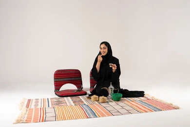 امرأة سعودية مع القهوة العربية على بساط تقليدي
