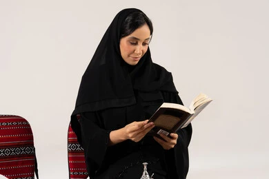 Saudi Woman in Black Abaya Reading a Book