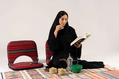 Saudi Woman Reading Book with Arabic Coffee