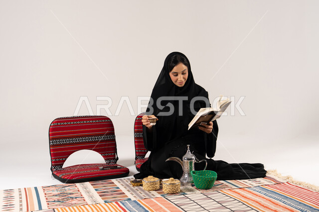 امرأة إماراتية تقرأ كتاباً في جلسة تراثية