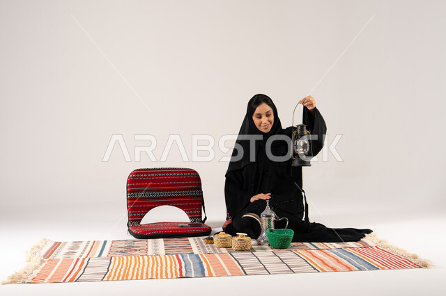 امرأة سعودية مع فانوس تقليدي وديكور سدو