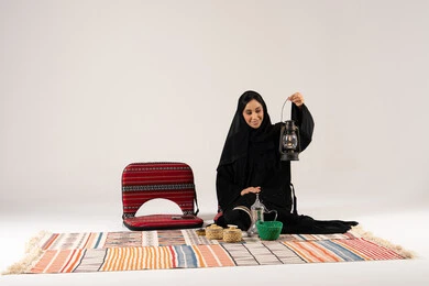 امرأة سعودية مع فانوس تقليدي وديكور سدو