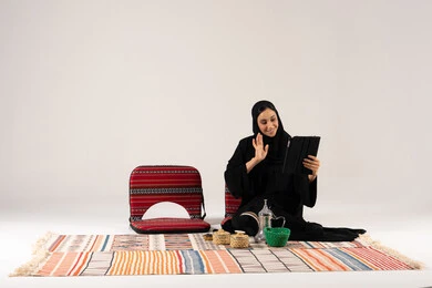 امرأة سعودية تستخدم جهاز لوحي في جلسة شعبية