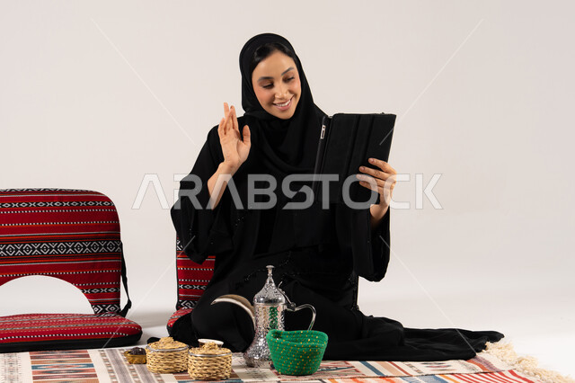 امرأة سعودية في مكالمة فيديو مع ديكور تراثي