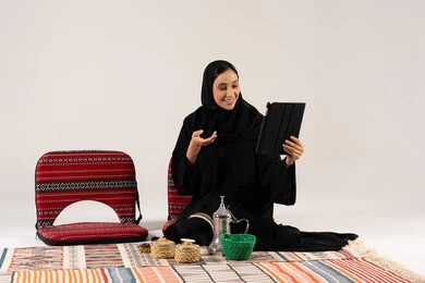 امرأة سعودية تستخدم الجهاز اللوحي في جلسة شعبية