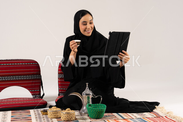 Saudi Woman with Tablet and Traditional Arabic Coffee
