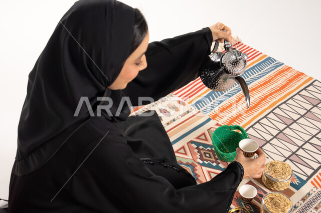 Saudi Woman Pouring Traditional Arabic Coffee in Abaya