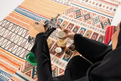 Woman in Abaya Pouring Arabic Coffee on Sadu Rug
