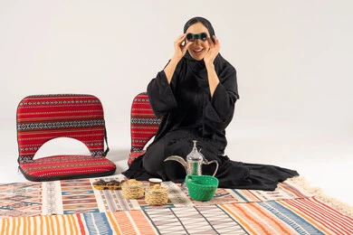 امرأة سعودية مع منظار وطقم قهوة تقليدي
