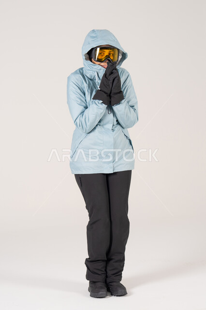 Woman in Winter Ski Clothing Shivering on White Background