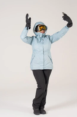 امرأة عربية بملابس التزلج الشتوية تلتقط سيلفي أمام خلفية بيضاء