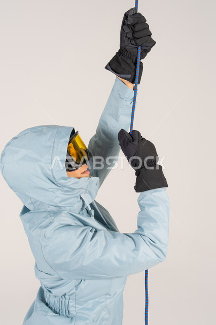 شخص يرتدي ملابس شتوية يتسلق بالحبل