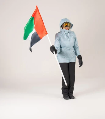 امرأة إماراتية بملابس التزلج تحمل علم الإمارات