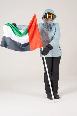 امرأة إماراتية بزي التزلج تحمل علم الإمارات