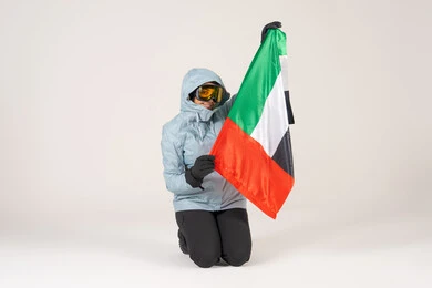 شخص بملابس الشتاء يحمل علم الإمارات العربية المتحدة