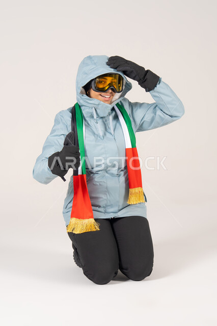 امرأة إماراتية بملابس التزلج ووشاح علم الإمارات