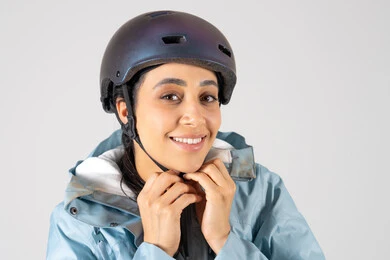 امرأة عربية تبتسم مرتدية خوذة رياضية واقية