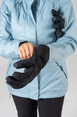 شخص يرتدي قفازات حرارية سوداء وسترة شتوية