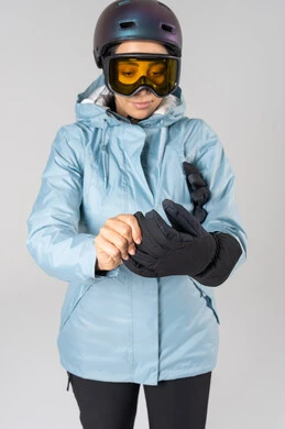 امرأة عربية بملابس التزلج ترتدي قفازات سوداء في الاستوديو