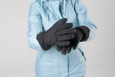 شخص يرتدي قفازات شتوية سوداء وسترة زرقاء