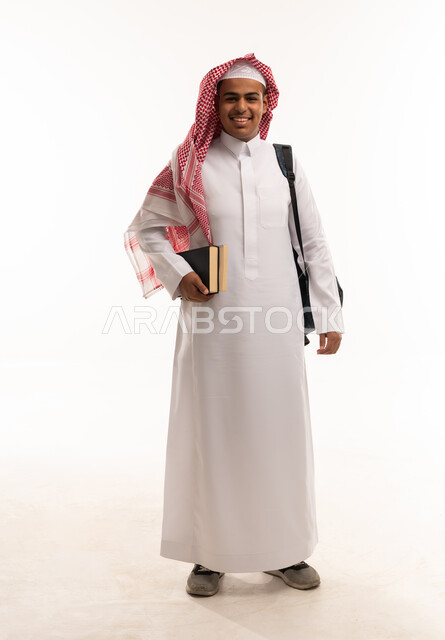 طالب سعودي بالثوب التقليدي يحمل كتباً