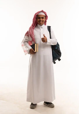 طالب سعودي يحمل حقيبة وكتب مع إشارة الإبهام