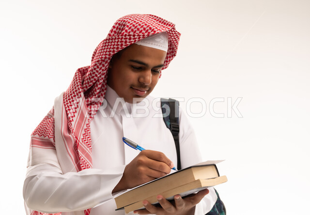 Saudi Male Student Writing on Books in Studio
