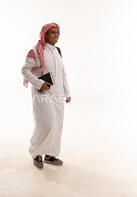 Saudi Man in Traditional Thobe Walking with Book
