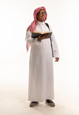 طالب سعودي يحمل كتاباً وحقيبة ظهر طالب سعودي يحمل كتاباً وحقيبة ظهر