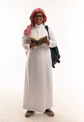 طالب سعودي بالثوب التقليدي يحمل كتاباً
