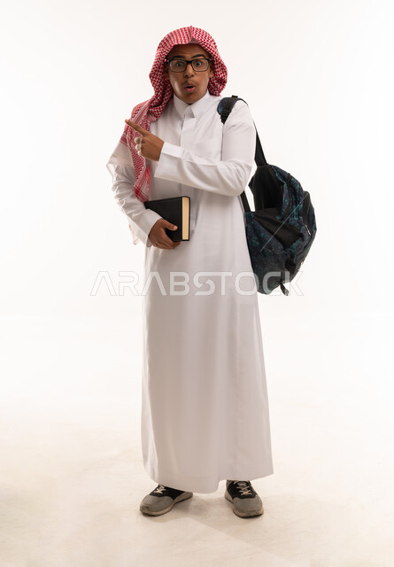 طالب سعودي مندهش مع حقيبة ظهر وكتاب