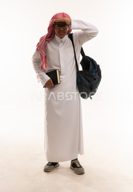 طالب سعودي يرتدي الثوب التقليدي والشماغ ويحمل حقيبة