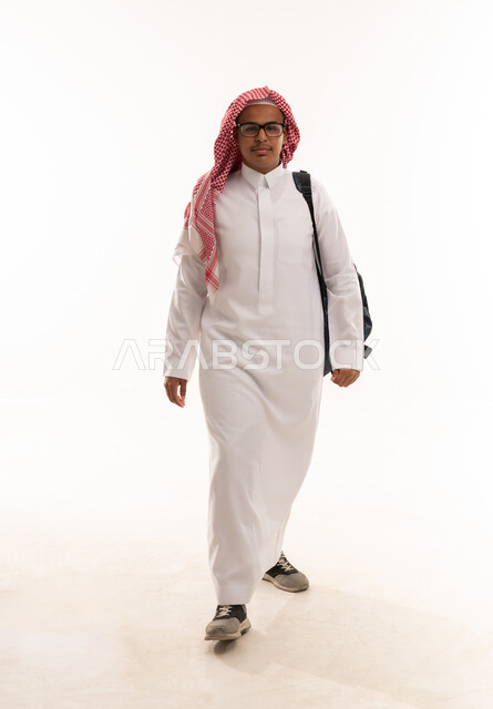 طالب سعودي بالثوب التقليدي يمشي مع حقيبة ظهر